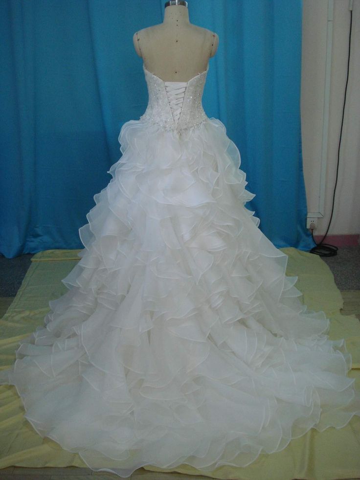 a wedding dress on display in front of a blue curtain