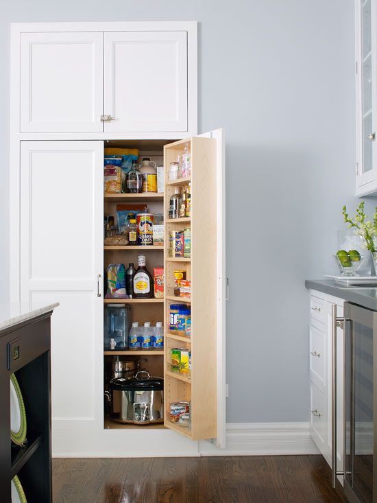 an open pantry door in a white kitchen