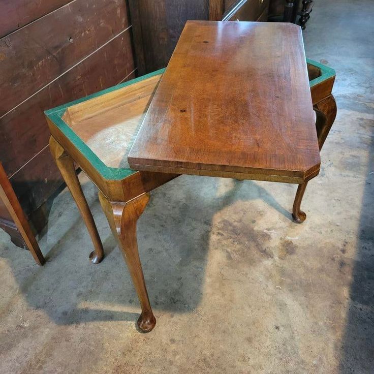 two wooden tables sitting next to each other on top of a cement floor in a room