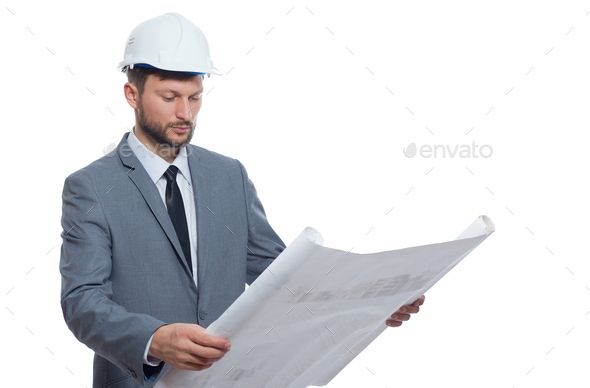 a man in a suit and hard hat reading a blueprint - stock photo - images