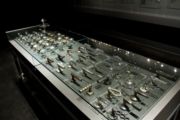 a glass display case filled with lots of silver items on top of a white table