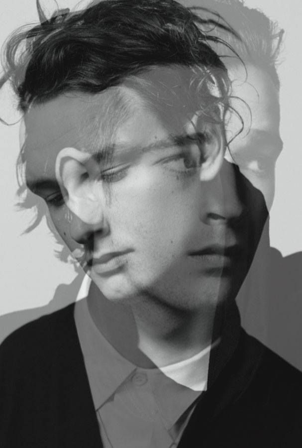 a black and white photo of a young man with his hair blowing in the wind