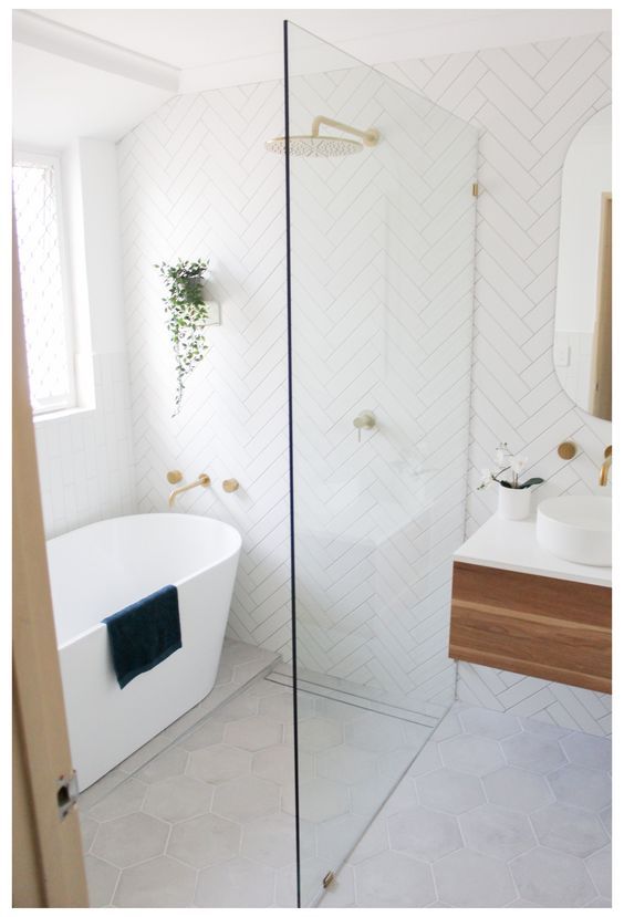 a bathroom with a glass shower door, sink and bathtub