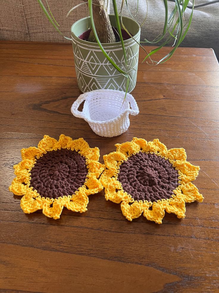 two crocheted sunflower coasters on a table