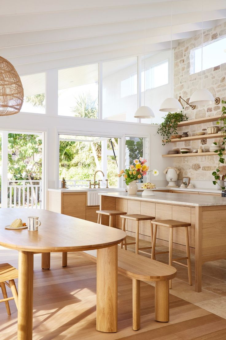 a kitchen with wooden floors and an island in the middle, surrounded by open windows