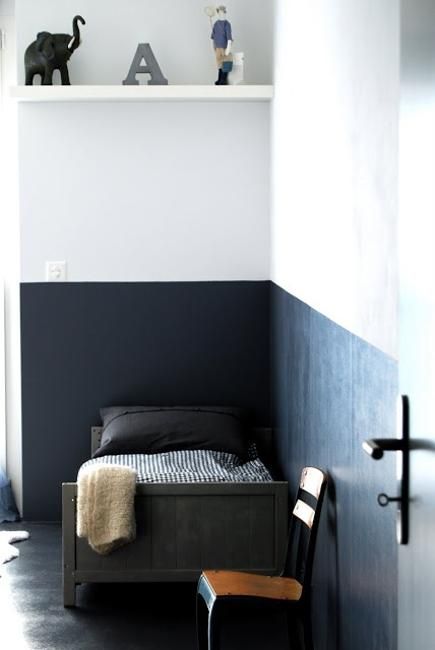 a bed sitting next to a wall in a bedroom