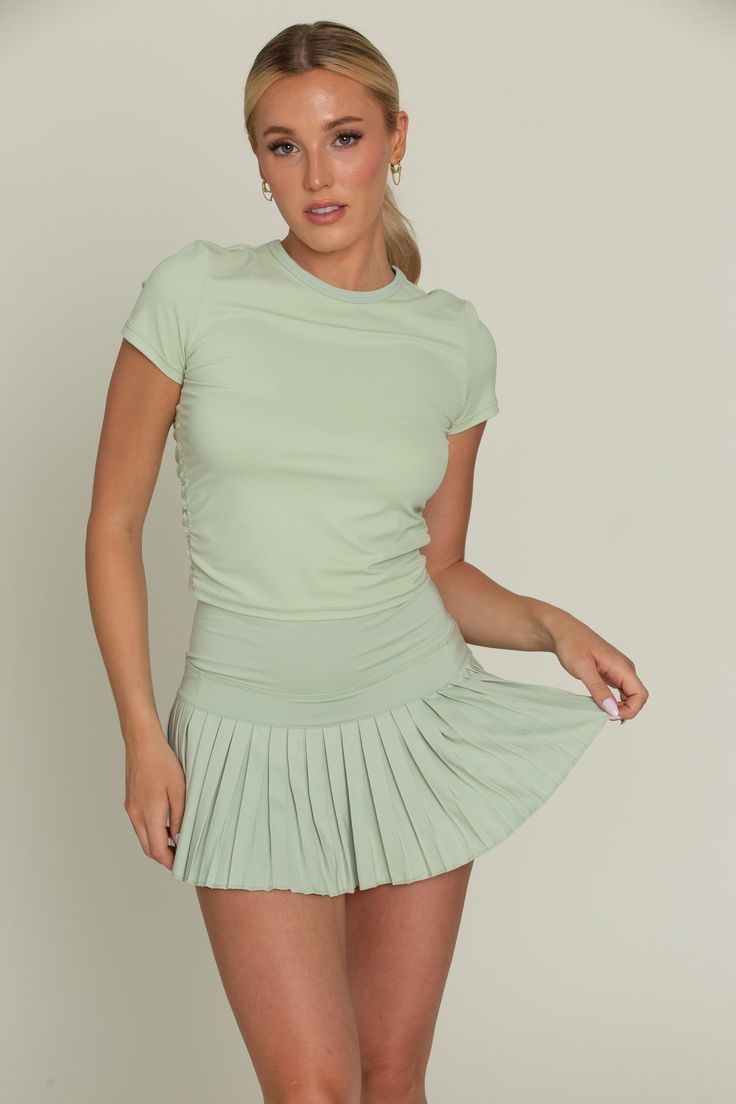 Our Pastel Green Pleated Tennis Skirt is the best everyday piece to add to your wardrobe because of its versatility & functionality. The skirt features built-in spandex shorts that include a comfortable fit and side pockets for storage. This exclusively designed Gold Hinge skirt is made of quick dry material and can take on any activity such as golf, tennis, running and more. Versatile Fitted Tennis Skirt With Built-in Shorts, Casual Fitted Skort With Elastic Waistband, Fitted Tennis Skirt With Built-in Shorts, Fitted Green Skirt For Sports, Fitted Tennis Skirt With Built-in Shorts For Workout, Fitted Tennis Skirt With Pockets, Fitted Tennis Skirt With Pockets For Workout, Summer Green 4-way Stretch Tennis Skirt, Green 4-way Stretch Tennis Skirt For Summer