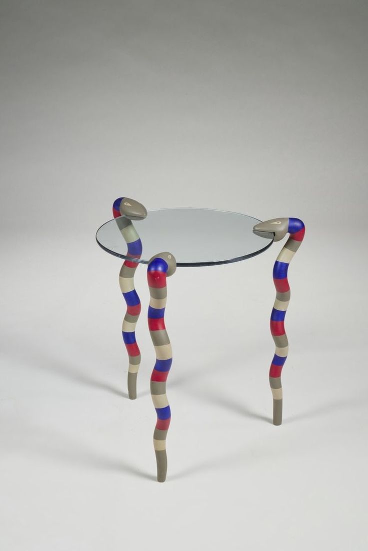 a glass table with two wooden legs and a glass top that has red, white, and blue stripes on it