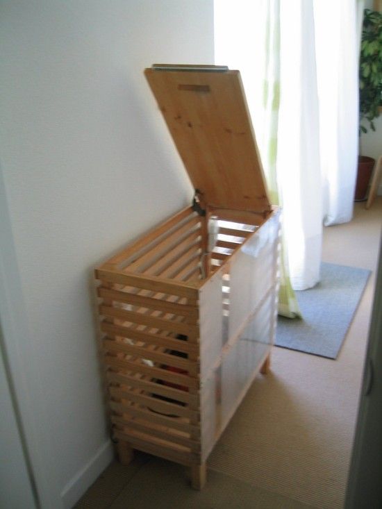 a wooden box sitting on top of a floor next to a window