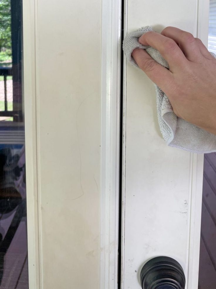 a hand with a rag on the handle of a door