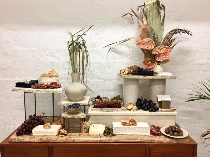 a table topped with lots of different types of food and flowers on top of it