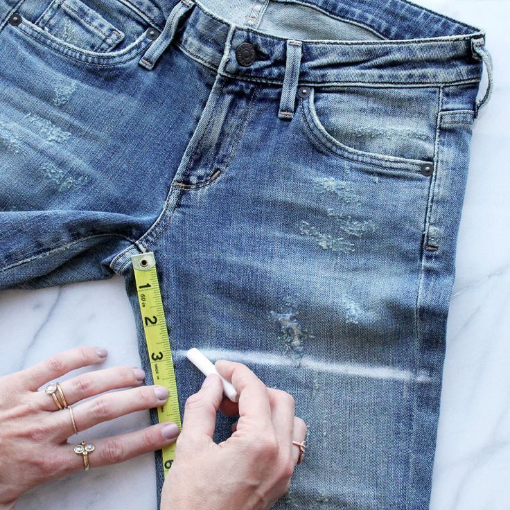 someone is measuring their jeans with a tape