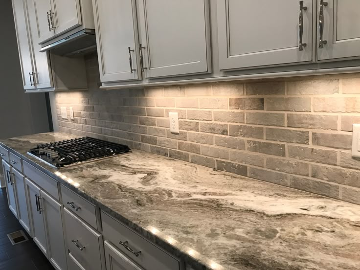 a kitchen with marble counter tops and white cabinets