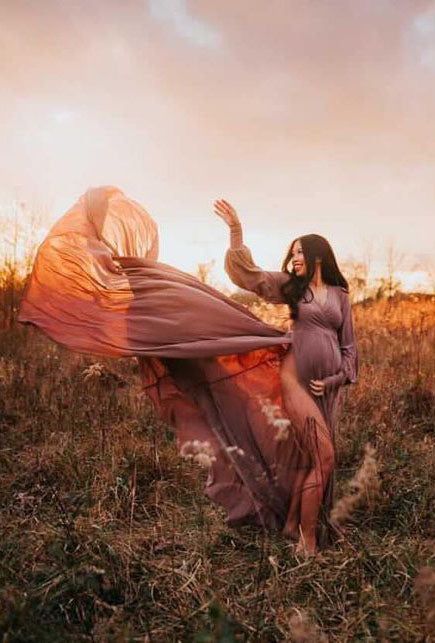 a pregnant woman is standing in a field