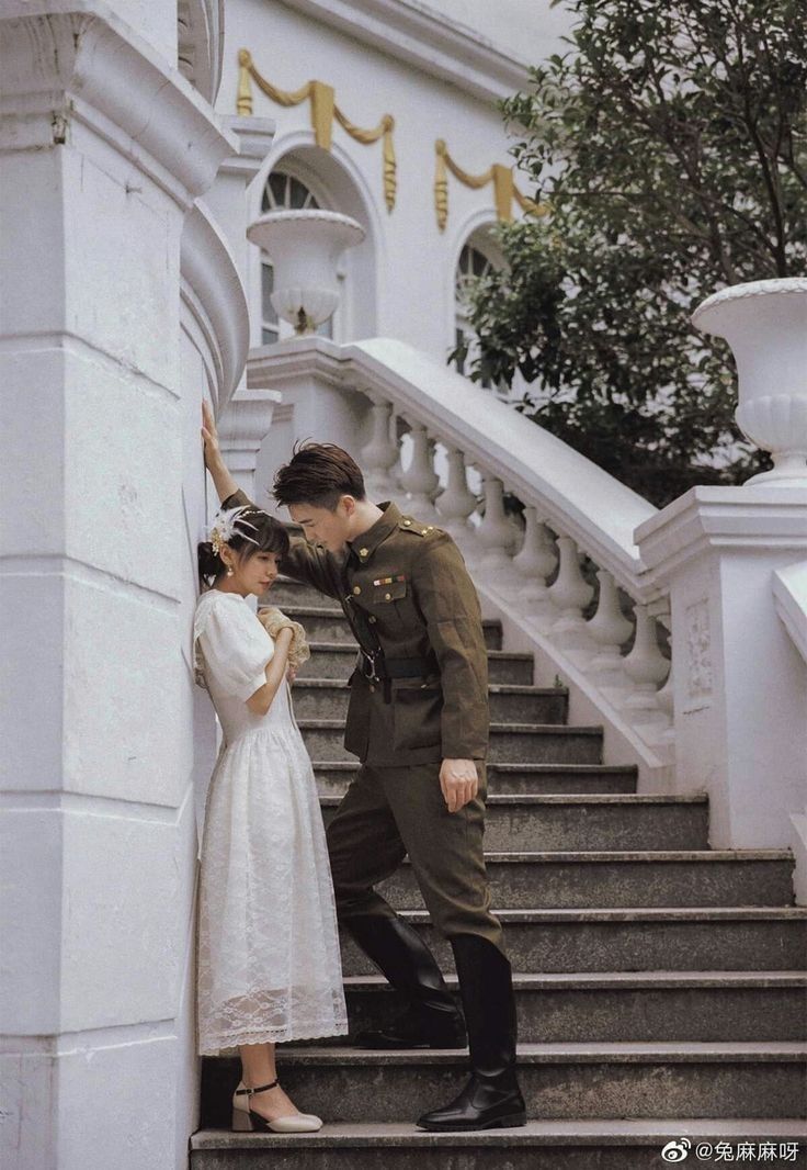 a man and woman are standing on the stairs