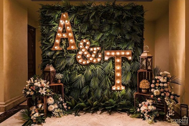 an indoor area with lights and greenery on the wall, decorated with letters that spell out love