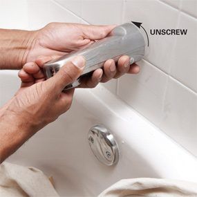 a person using a handheld shower head in a bathtub with instructions on how to use it