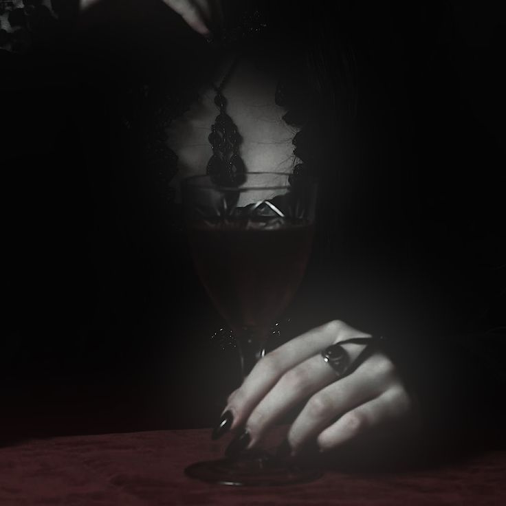 a woman's hands holding a glass of wine