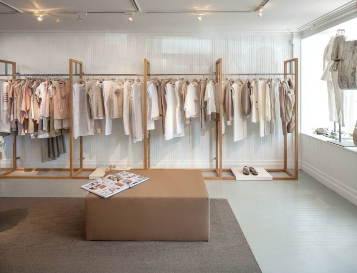 a clothing store with lots of clothes hanging on the wall and shoes on the floor