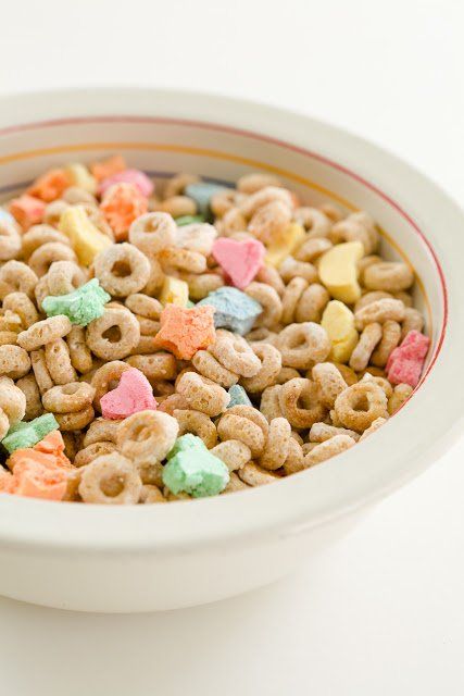 a white bowl filled with cereal and pretzels