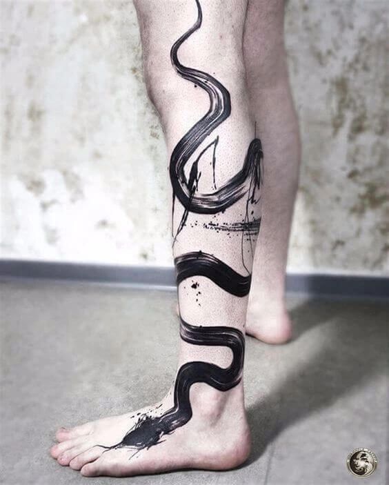 a man's leg with a black and white tattoo design on the bottom of it