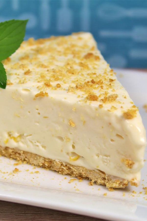 a piece of cheesecake on a white plate with a green leaf garnish