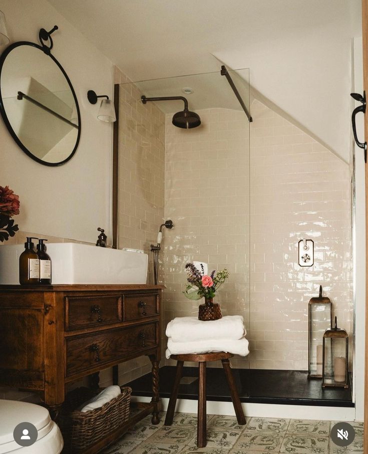 a bathroom with a sink, toilet and shower in it's corner area next to a dresser