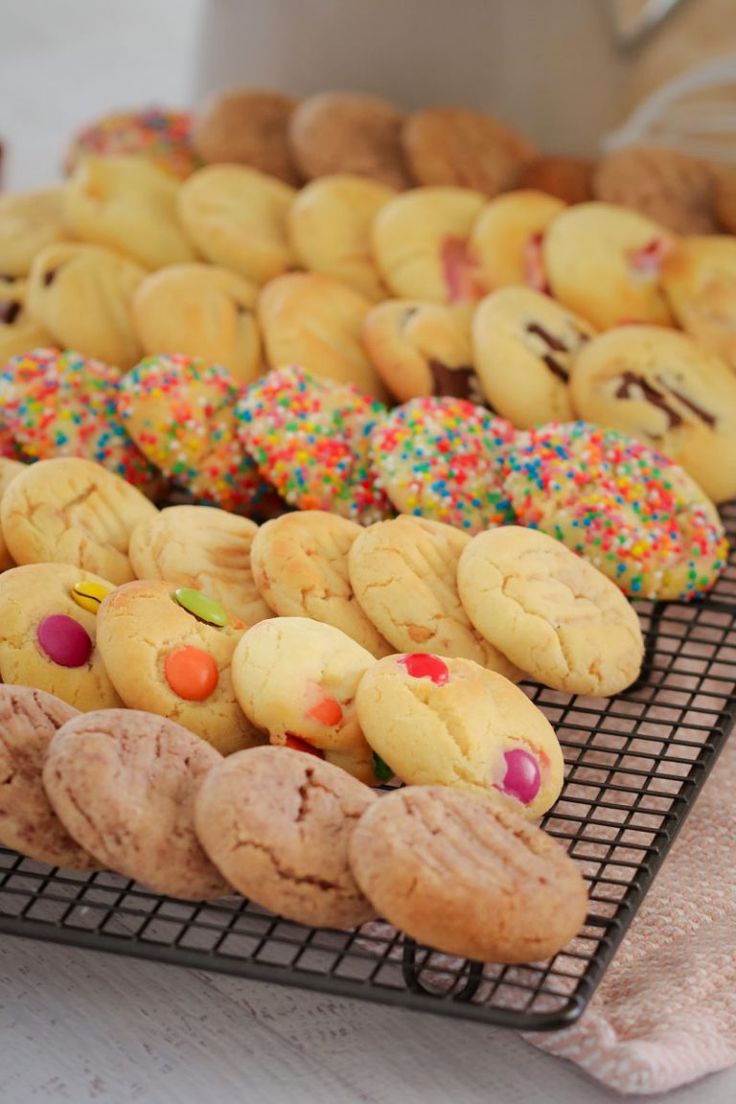 there are many cookies on the rack and one has sprinkles in it