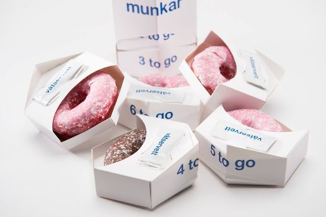 four boxes with donuts in them sitting next to each other on a white surface