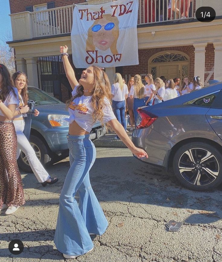 two women are dancing in the street while holding a sign