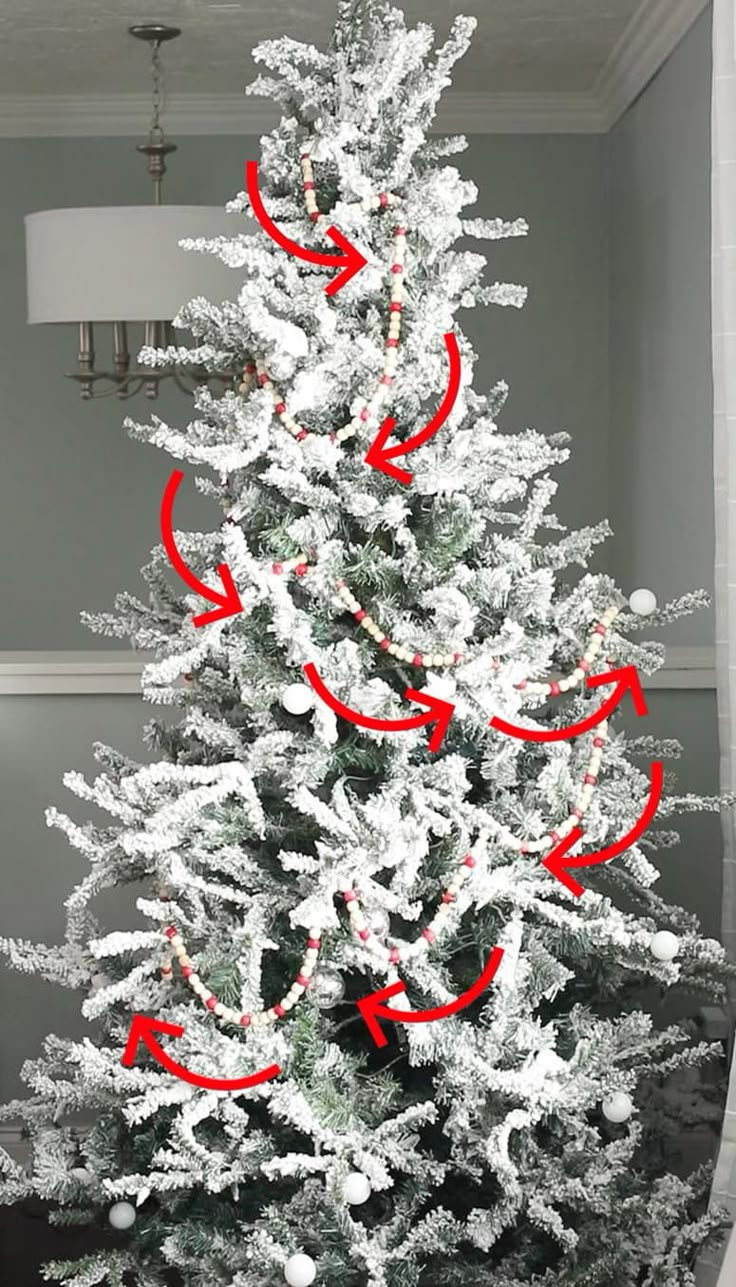 a white christmas tree with red arrows pointing in the direction of an arrow on it