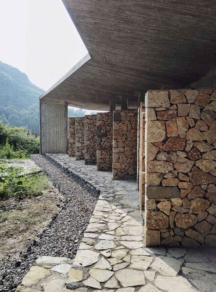 the stone walkway is lined up against the building's roof and sidewalls