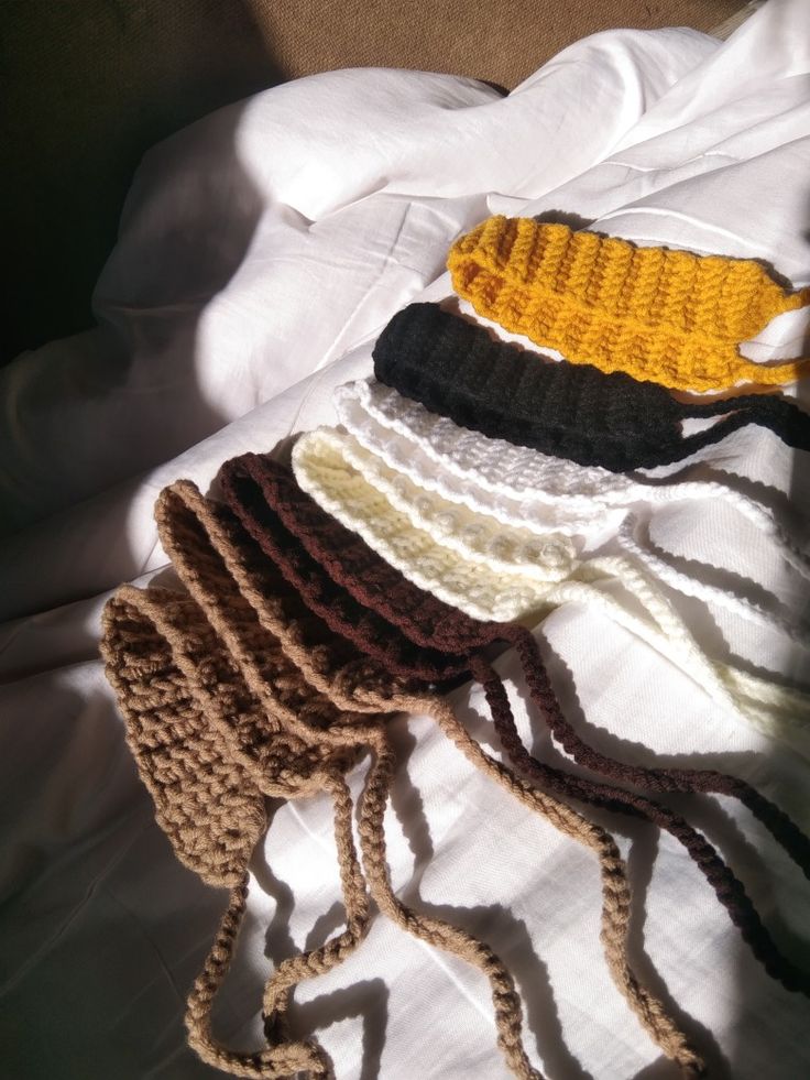 several knitted hats laying on top of each other