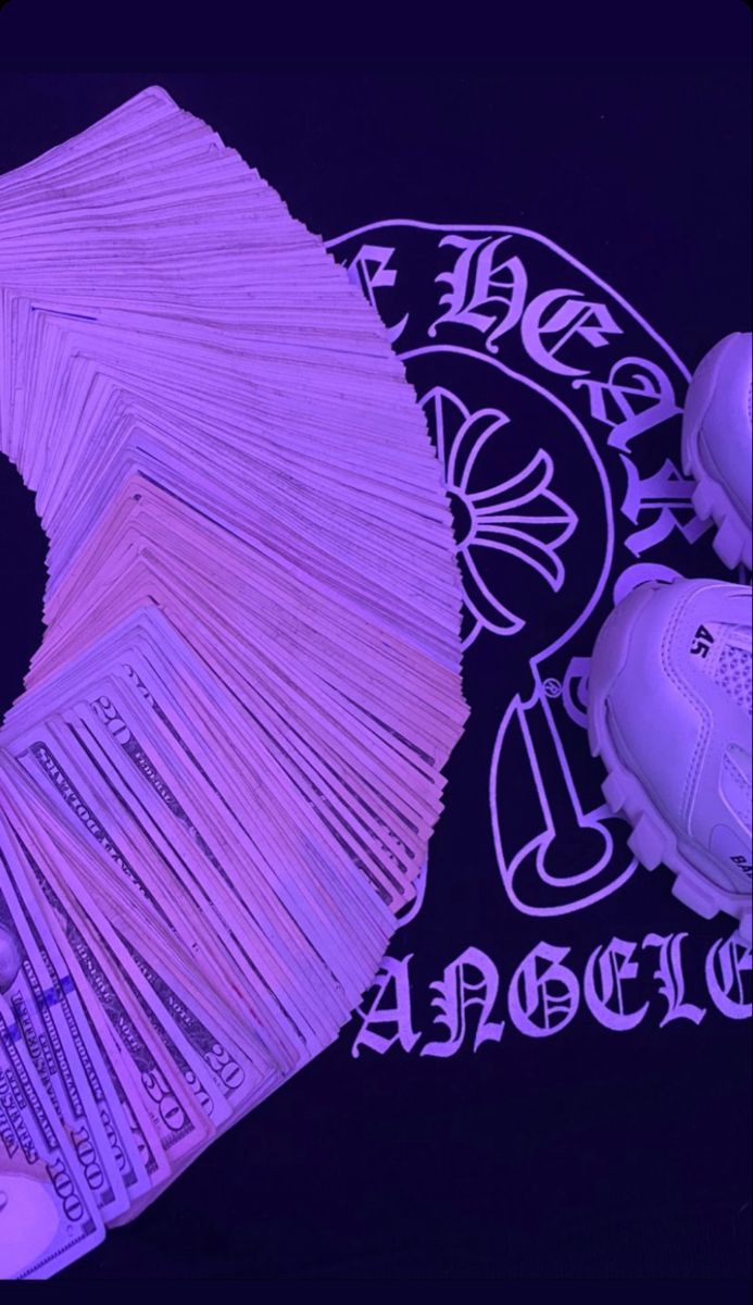 a pile of money sitting next to purple sneakers