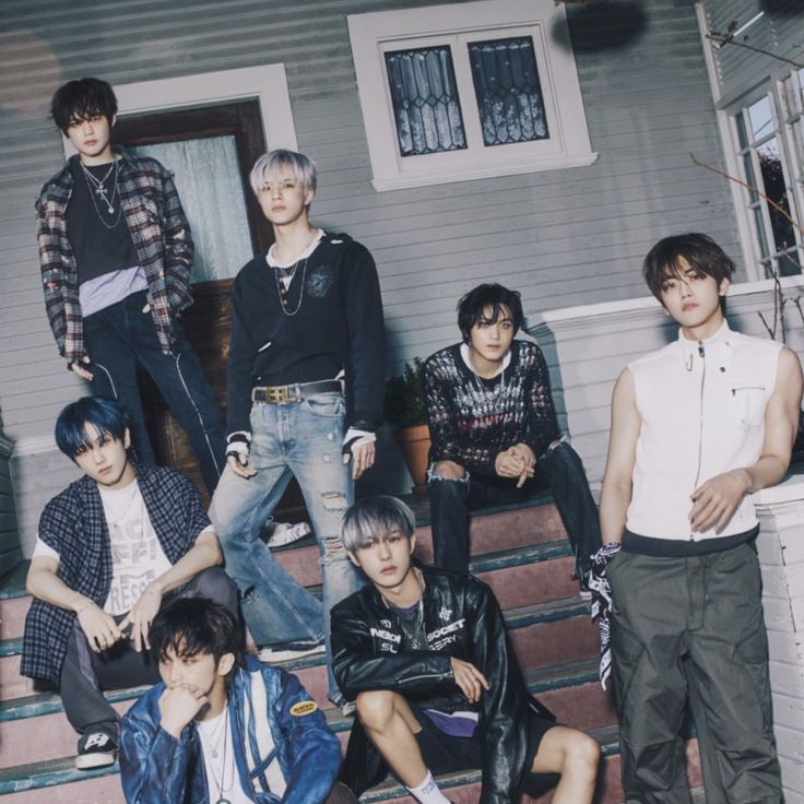 a group of young men standing next to each other in front of a house with stairs