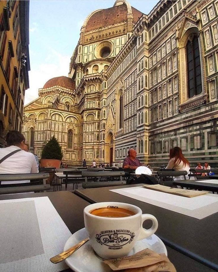 a cup of coffee sitting on top of a white plate