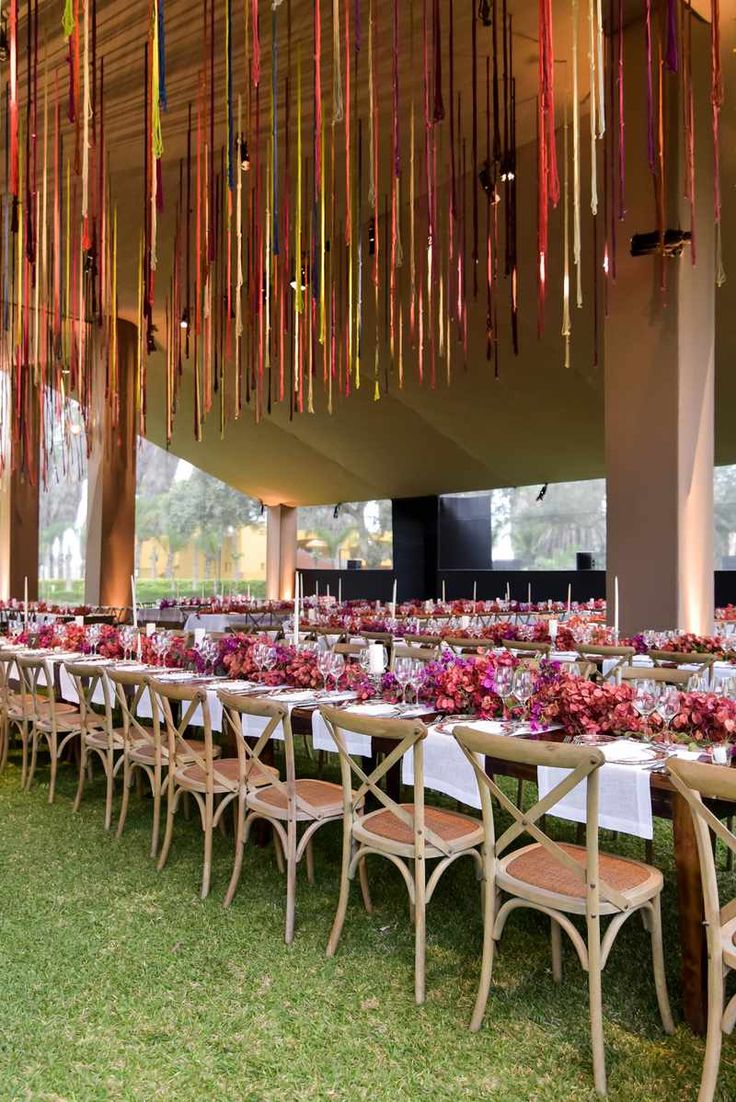 a long table is set up with flowers and candles for a wedding or reception in the grass