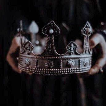 a person holding a silver crown in their hands