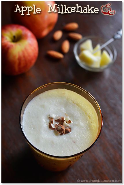 an apple milkshake in a glass next to some nuts