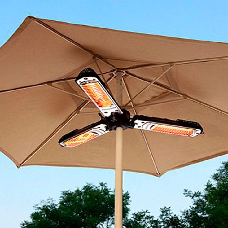 an umbrella with two lights on it in front of some trees and blue sky,