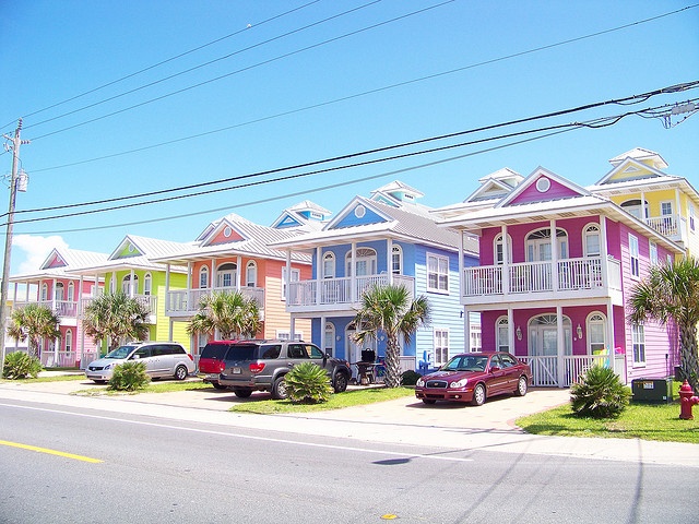 the front cover of a magazine with cars parked in front of colorful houses and palm trees