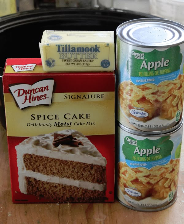 two cans of apple cake next to a can of cinnamon apples and some other desserts