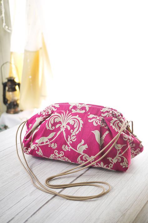 a pink purse sitting on top of a wooden table