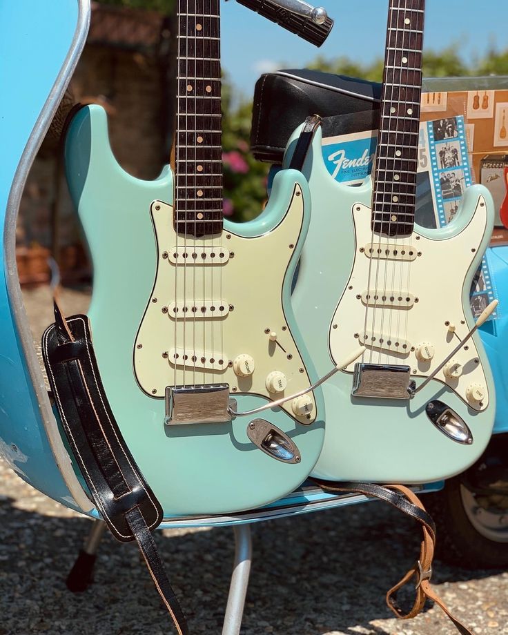 two electric guitars sitting on top of each other