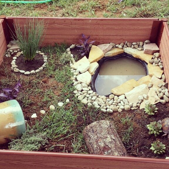 a wooden box filled with rocks and plants