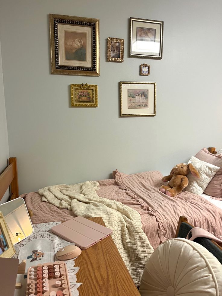 a bed room with a neatly made bed and several pictures on the wall above it