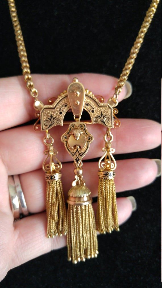 Victorian Tassel necklace made from 14k Yellow Gold, weight is 42 Grams.Can be wear as a Necklace or as a Brooch.Pendant- Brooch is 3 1/4" longChain is 19" long.Perfect Antique condition.Clasp on the front..Look Spectacular on your Neck.Layaway plan is Available.Antique Box For DISPLAY Only.Last pic to compare prices with Similar Item from other seller for much higher price... Victorian Style Brass Necklace With Intricate Design, Victorian Brass Necklace With Intricate Design, Victorian Gold Rectangular Necklace, Victorian Gold Brass Necklace, Victorian Gold Pendant Brooches, Gold Pendent, Gold Tassel Necklace, Imperial Topaz, Victorian Jewelry