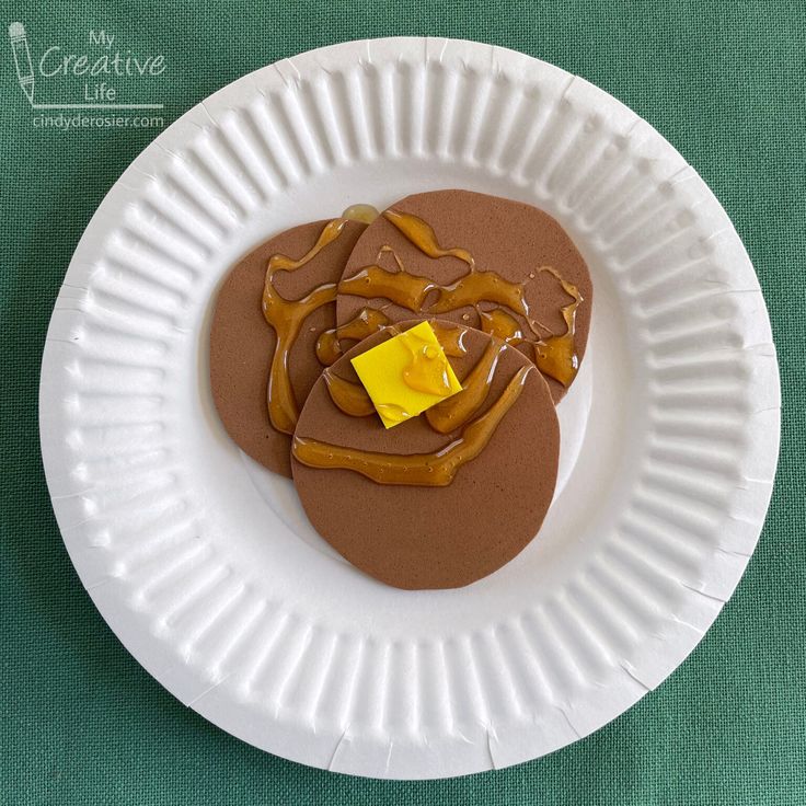 a paper plate that has some kind of dessert on it with chocolate and caramel