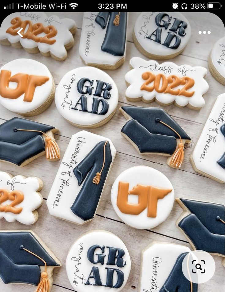 decorated cookies with graduation caps and tassels are arranged on a wooden table top