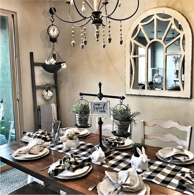 a dining room table set for four with place settings on the table and decorations hanging from the chandelier